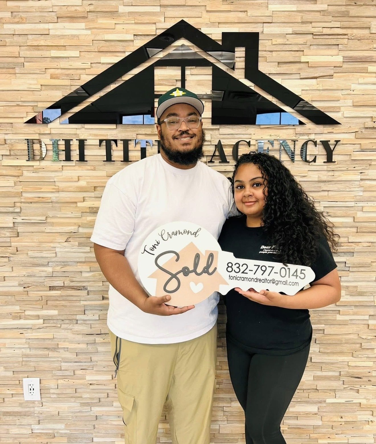 Buyer clients holding their SOLD key sign from Toni Cramond at closing